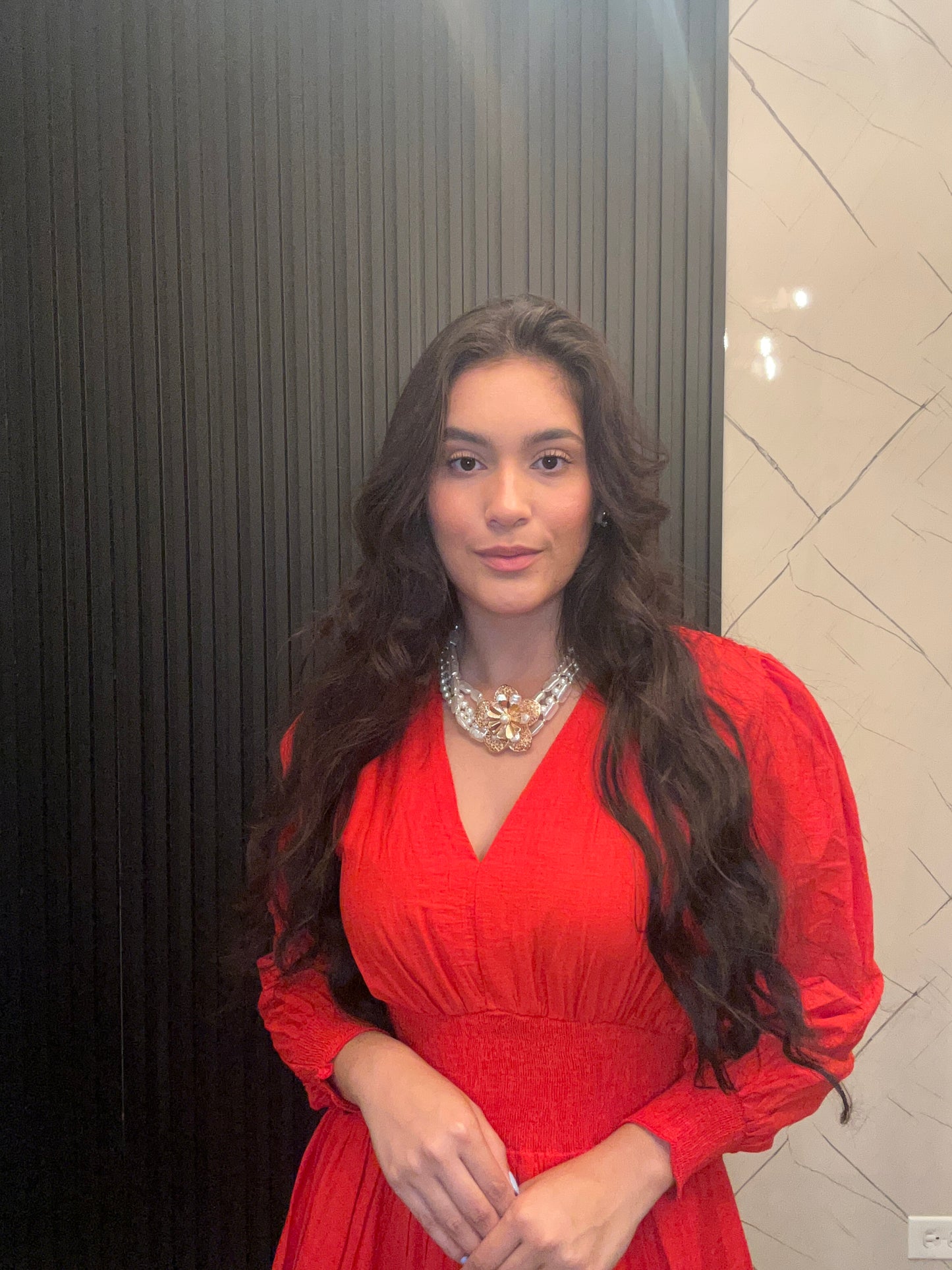 Woman in a red dress standing in front of a mirror.