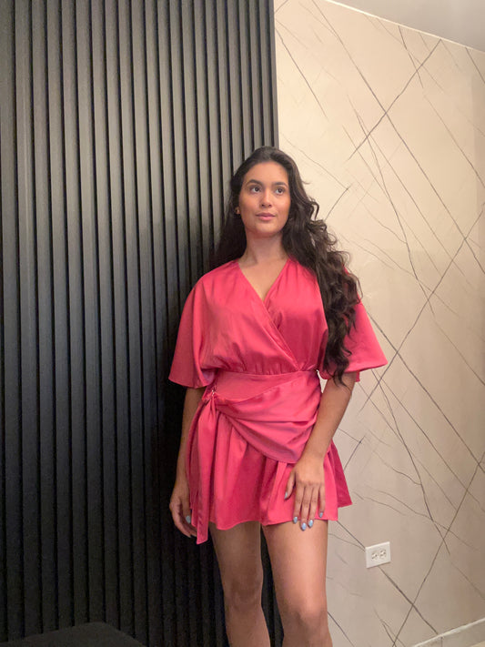 Woman in a pink dress standing on a tiled floor